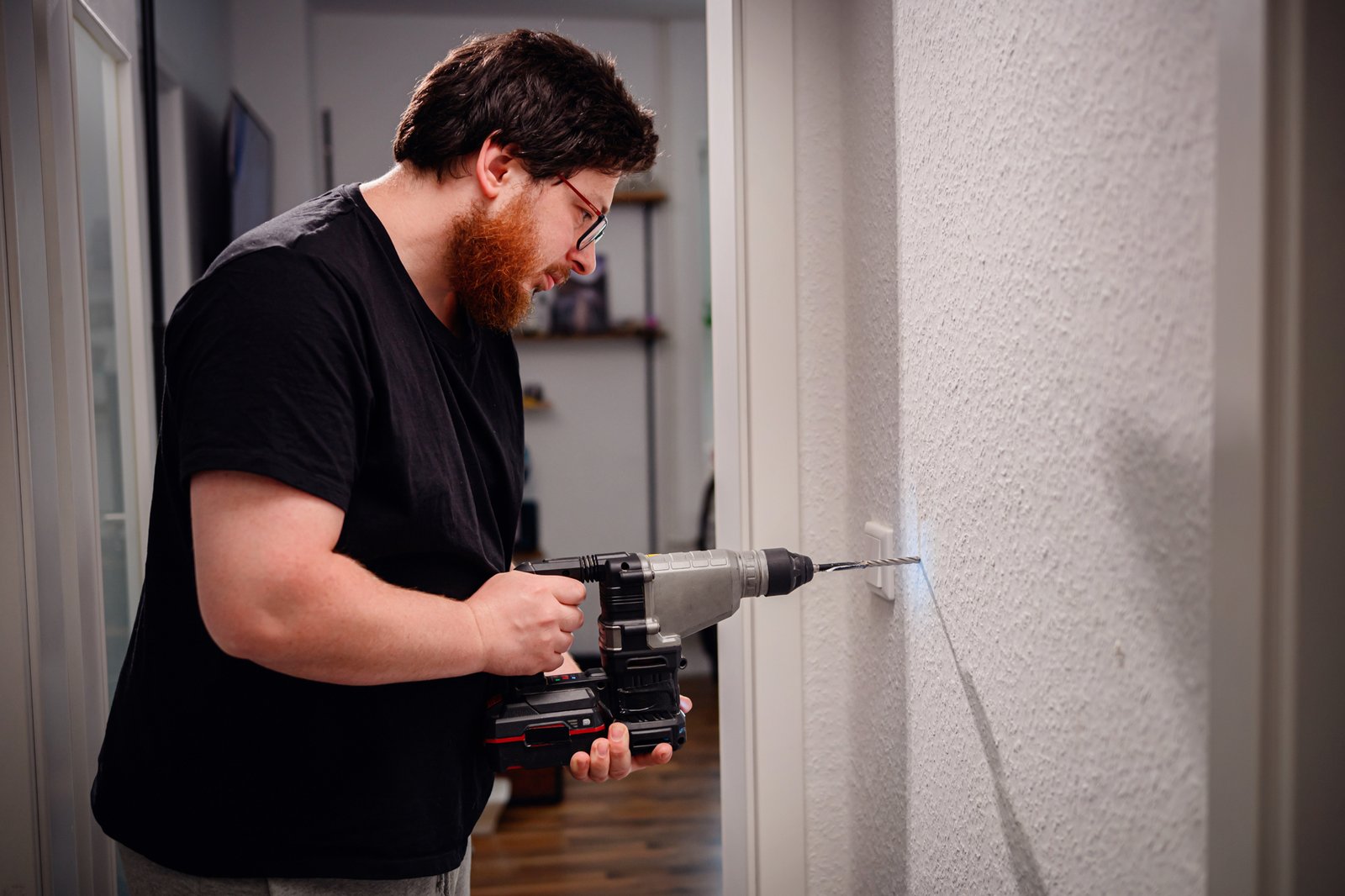Nachbar bohrt mit einer Bohrmaschine in der Wohnung