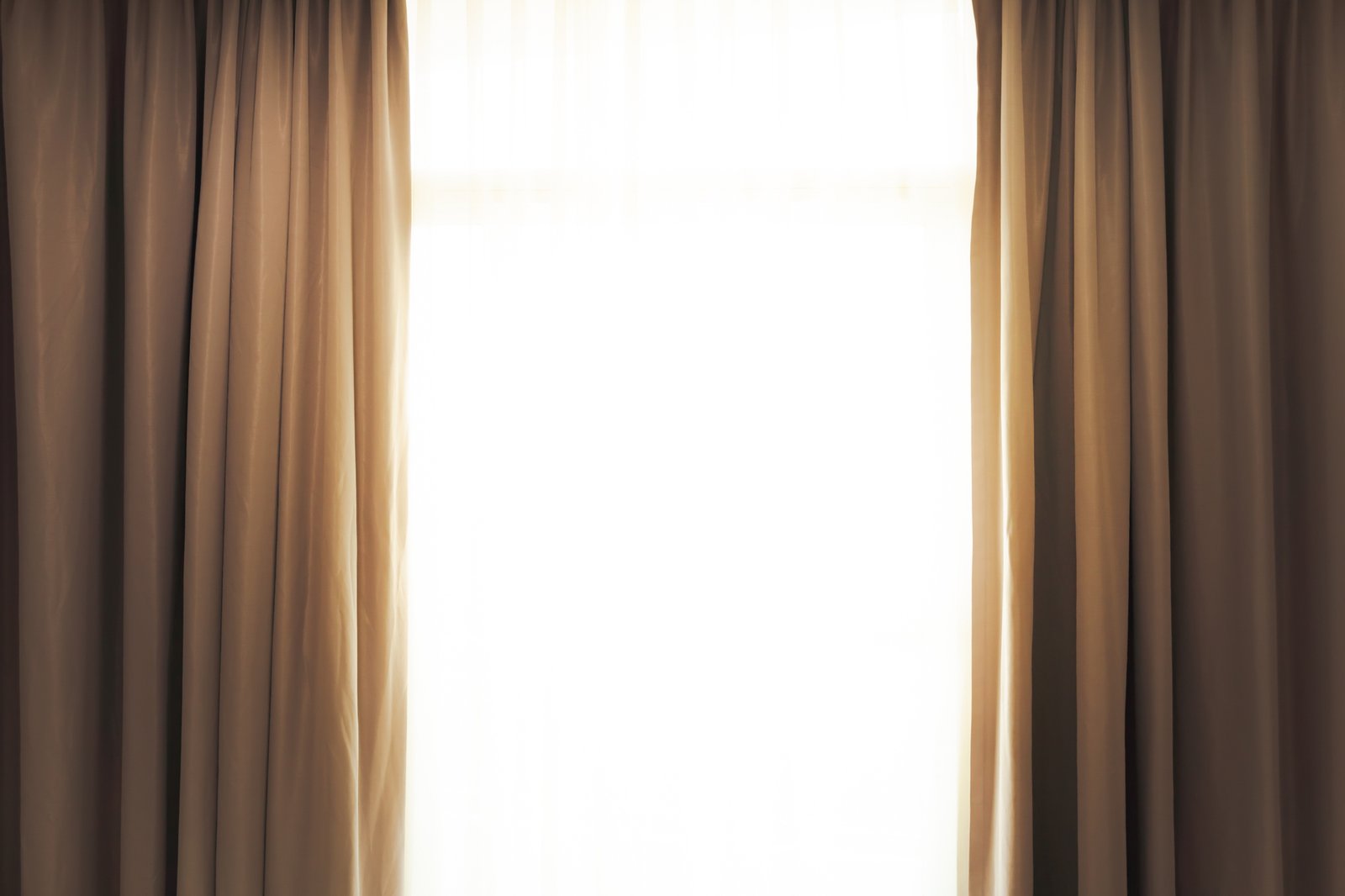 Schwere Vorhänge hängen vor einem großen Wohnzimmerfenster